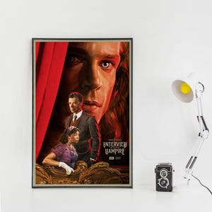 May include: Framed poster featuring the movie "Interview with the Vampire." The artwork showcases three characters with a large face in the background. The poster has a red curtain on the left and the movie title on the right.