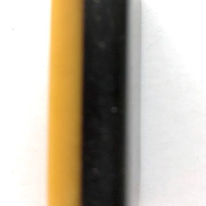 May include: A rectangular object, bisected vertically, with a yellow-tan color on the left and black on the right. The object has rounded edges and a smooth, glossy finish. The item is set against a white background.
