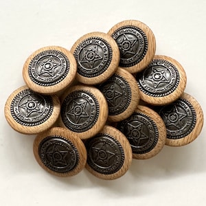 May include: A collection of 10 round wooden buttons with a silver star design and the text "Great Seal of the State of Oklahoma" around the star. The buttons are arranged in a circular pattern.
