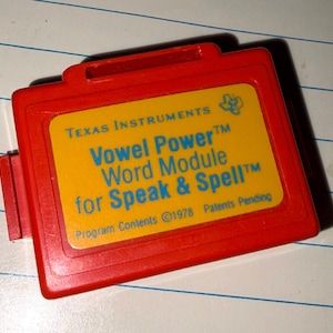 May include: A red Texas Instruments Vowel Power Word Module for Speak & Spell. The module has a yellow label with blue text. The text includes "Program Contents ©1978 Patents Pending".