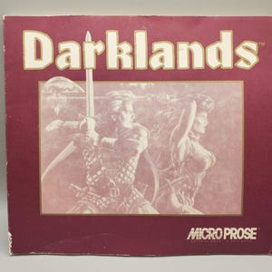 Könnte beinhalten: Burgunderfarbene Box mit dem Titel "Darklands" in großen, weißen Blockbuchstaben. Die Box zeigt eine Illustration von zwei Figuren, die Schwerter schwingen. Das Micro Prose-Logo befindet sich unten.