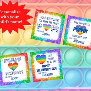 Op de afbeelding: Vier printbare Valentijnsdagkaarten met een regenboog pop-it speelgoedontwerp. De kaarten zeggen "Valentine you make my heart pop!" "Hope you have a poppin' Valentine's Day!" "Thanks for making my Valentine's Day poppin'" en "Just poppin' by to say Happy Valentine's Day!"