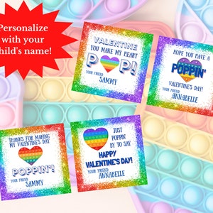 Op de afbeelding: Vier printbare Valentijnsdagkaarten met een regenboog pop-it ontwerp. De kaarten zeggen "Valentine you make my heart pop!" "Hope you have a poppin' Valentine's Day!" "Thanks for making my Valentine's Day poppin'" en "Just poppin' by to say Happy Valentine's Day!"