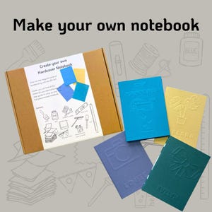 May include: A brown box with the text "Create your own Hardcover Notebook" on the front. The box contains a kit for making a notebook with different coloured covers and embossed designs. The covers include a blue cover with a camera design, a blue cover with a plant design, a yellow cover with a plant design, and a green cover with a bow design.
