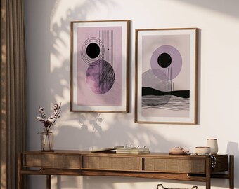 Op de afbeelding: Twee ingelijste abstracte kunstprints met geometrische vormen en een paarse achtergrond. De prints hangen aan een witte muur boven een houten tafel.