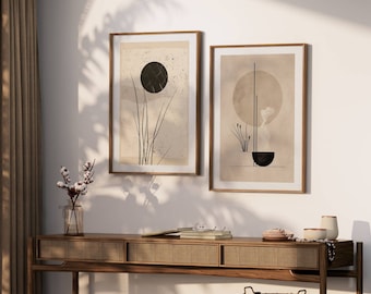 Könnte beinhalten: Zwei gerahmte abstrakte Kunstdrucke mit minimalistischen Designs in Schwarz, Weiß und Beige. Die Drucke hängen an einer weißen Wand über einem Holz-Konsolentisch.