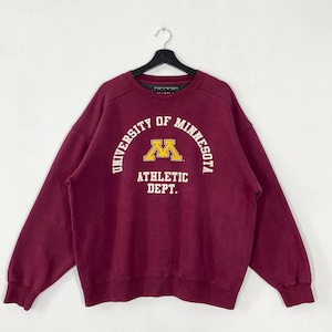 May include: A maroon sweatshirt with the text "UNIVERSITY OF MINNESOTA ATHLETIC DEPT." in white and a yellow "M" logo. The sweatshirt is hanging on a black hanger against a white background.