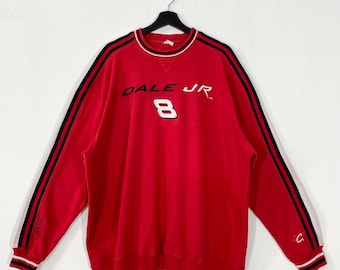 May include: Red sweatshirt with black and white stripes on the sleeves and collar. The front features the text "DALE JR" above the number "8" in white. The sleeves have a black stripe with two white stripes.