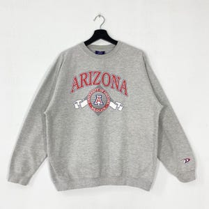 Suéter vintage University Arizona, suéter com gola redonda University Arizona, pulôver com estampa do logotipo Arizona Wildcats, cinza médio