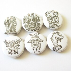 May include: Six white round buttons with black and white images of gargoyles. The gargoyles are in various poses and expressions.