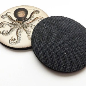 May include: A round coaster with a vintage illustration of an octopus on a white background. The back of the coaster is black.