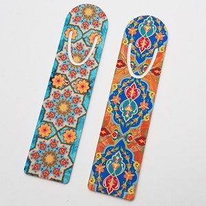 May include: Two colorful bookmarks with intricate geometric patterns. The bookmark on the left has a blue background with orange, yellow, and red details. The bookmark on the right has an orange background with blue, red, and yellow details.
