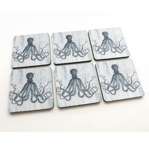 May include: Set of six blue and white coasters featuring an octopus design. The coasters are made of wood and have a distressed look.