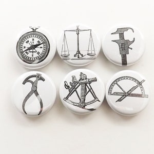 May include: Set of six 1-inch diameter white button pins with black and white illustrations of scientific instruments. The illustrations include a compass, a scale, calipers, dividers, a sextant, and a protractor.