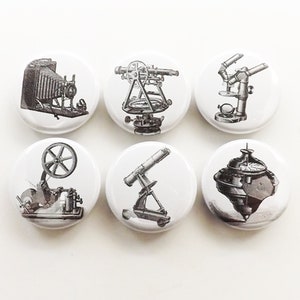 May include: Six vintage scientific instruments, including a camera, telescope, microscope, compass, and two other instruments, are depicted on white round buttons.