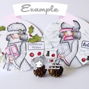 May include: Two round Christmas ornaments featuring illustrations of girls in winter clothing holding gifts. One ornament has the text "Christmas Wishes" and the other has the text "Believe".