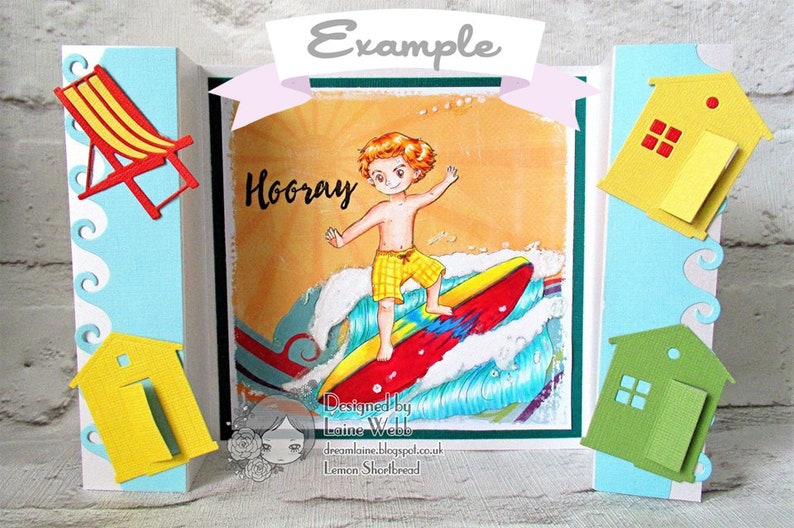 May include: A colorful card with a boy surfing on a wave. The card has a beach theme with yellow and green beach houses, a blue and white striped beach chair, and the word "Hooray" written on the front. The card is designed by Laine Webb.