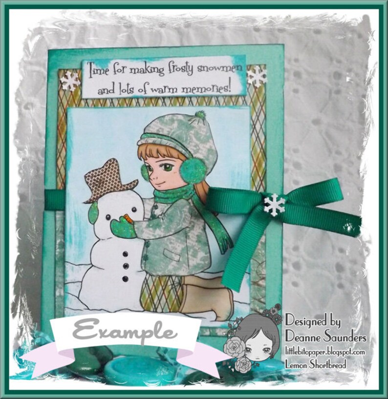 May include: A green and white card with a girl and a snowman. The card has the text "Time for making frosty snowmen and lots of warm memories!" and "Example". The card is designed by Deanne Saunders and is called "Lemon Shortbread".