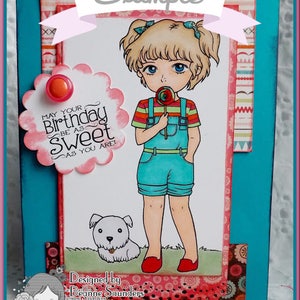 May include: A birthday card featuring a girl with blonde hair and blue eyes holding a lollipop. The card has a pink and white background with a scalloped border and the text "May your birthday be as sweet as you are!" The card is designed by Deanne Saunders.