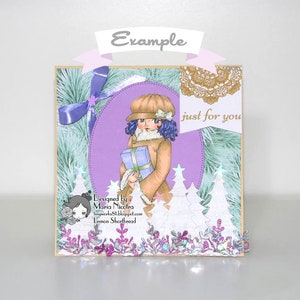 May include: A purple and white Christmas card with a girl holding a gift box. The card has a white lace doily, a blue ribbon, and the text "just for you".