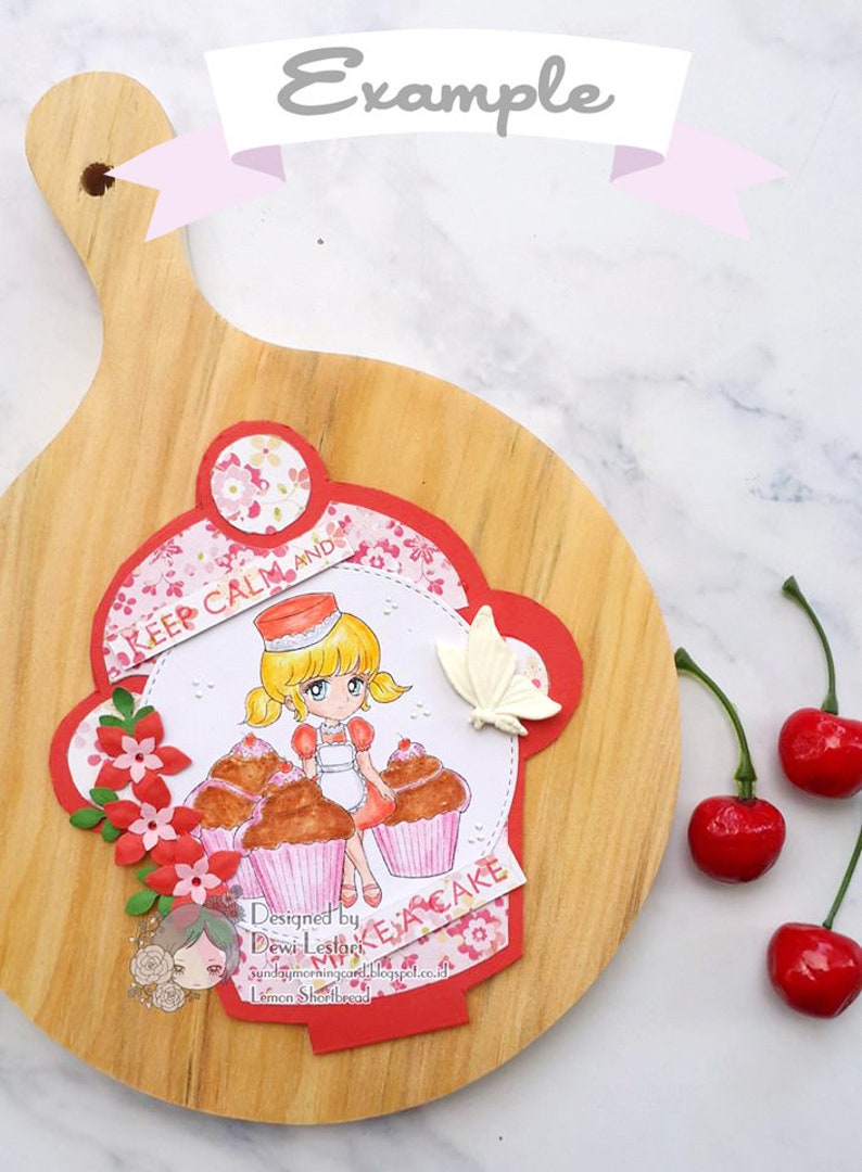 K&ouml;nnte beinhalten: Ein rotes und wei&szlig;es Papierhandwerk mit einem M&auml;dchen, das Cupcakes h&auml;lt und den Text "Keep Calm and Eat Cake". Das Handwerk befindet sich auf einem Holzbrett mit roten Kirschen an der Seite.