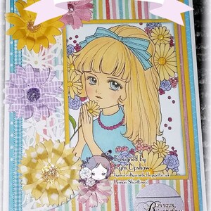 May include: A colorful card with a girl with blonde hair and a blue bow. The card has a striped background and flowers. The text on the card says "Example" and "On Your Birthday".
