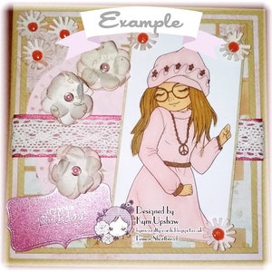 May include: A pink card with a girl wearing a pink hat and a pink sweater. The card has a white lace ribbon and a pink flower. The text on the card says "Example" and "Designed by Kym Upshaw Lemon Shortbread".