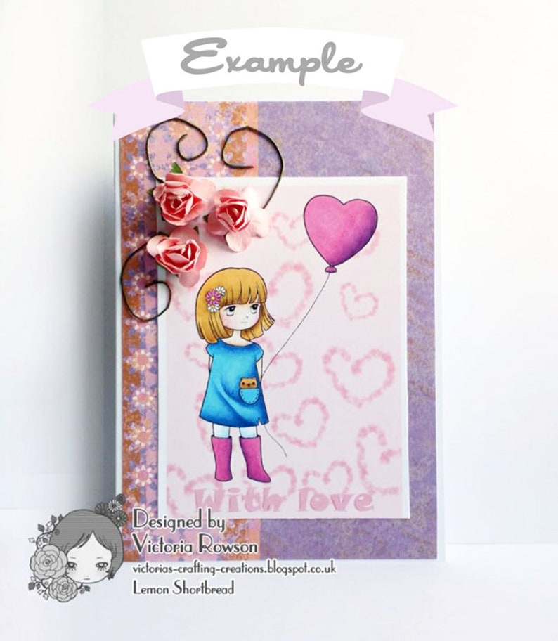 May include: A handmade card with a purple background and a pink heart balloon. A girl with blonde hair and a blue dress is holding the string of the balloon. The card has a pink and brown patterned border and the text "Designed by Victoria Rowson" and "With love" in pink letters.