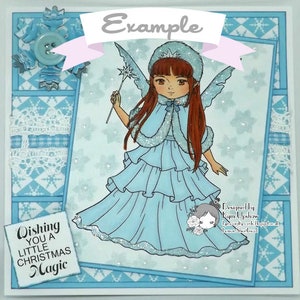 May include: A blue and white Christmas card with a snowflake design. The card features a cartoon fairy with long brown hair, a blue dress, and a wand. The text "Wishing you a little Christmas Magic" is printed on the card.