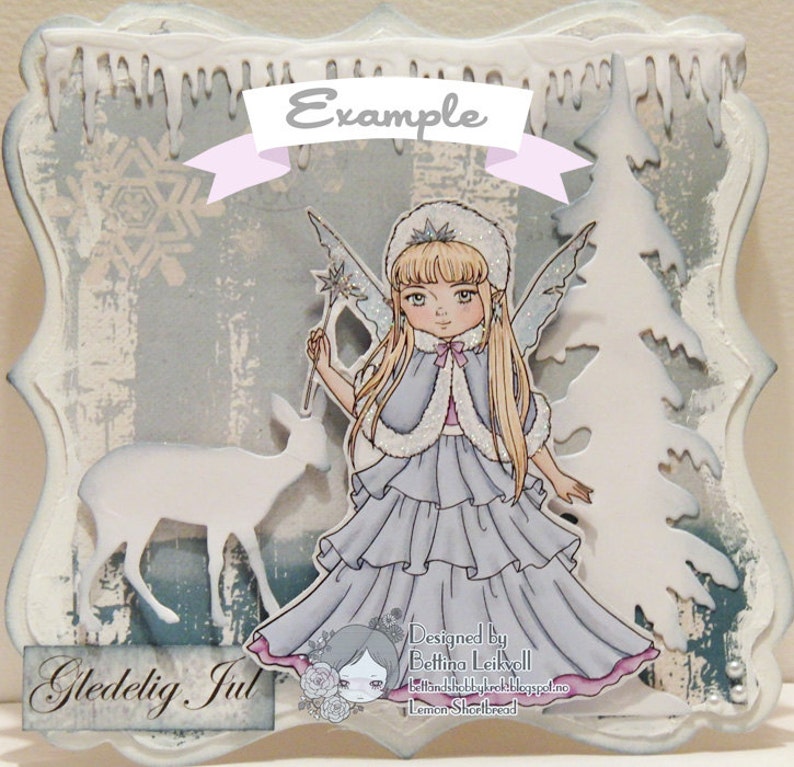 May include: A winter-themed card with a white background and a blue and white snowflake design. The card features a white deer silhouette, a fairy with blonde hair and a blue dress, and a white Christmas tree. The card has the text "Gledelig Jul" in brown lettering.