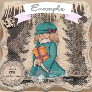May include: A handmade Christmas card featuring a girl in a teal coat holding a wrapped gift. The card has a white background with a blue and white polka dot pattern and a white mesh overlay. The card is decorated with a snowflake charm and the text "Have a Cool Holiday Season".