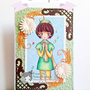 Peut inclure: Une carte faite &agrave; la main repr&eacute;sentant une fille aux cheveux bruns et &agrave; la robe verte, entour&eacute;e de feuilles d'automne et de fleurs. La carte est d&eacute;cor&eacute;e de d&eacute;coupes en papier brun et du texte "Designed by Victoria Rowson, victorias-crafting-creations.blogspot.co.uk Lemon Shortbread".