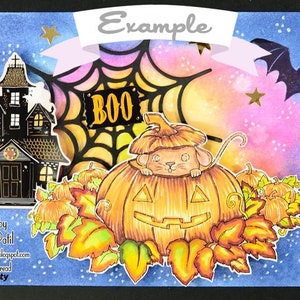 Pu&ograve; includere: Un biglietto di Halloween con una casa stregata, una ragnatela con la scritta "BOO" sopra, un pipistrello e un topo che sbircia da una zucca intagliata. Lo sfondo &egrave; un acquerello blu e viola con stelle dorate.