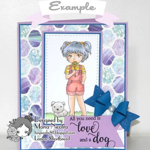 May include: A purple card with a girl and a dog on it. The girl has blue hair and is wearing a yellow and white striped shirt, pink overalls, and pink shoes. She is holding a lollipop. The dog is white and has black spots. The card has a blue bow with glitter on it. The text on the card reads "Designed by Maria Nicotra tinyworks81.blogspot.com Lemon Shortbread All you need is love and a dog".