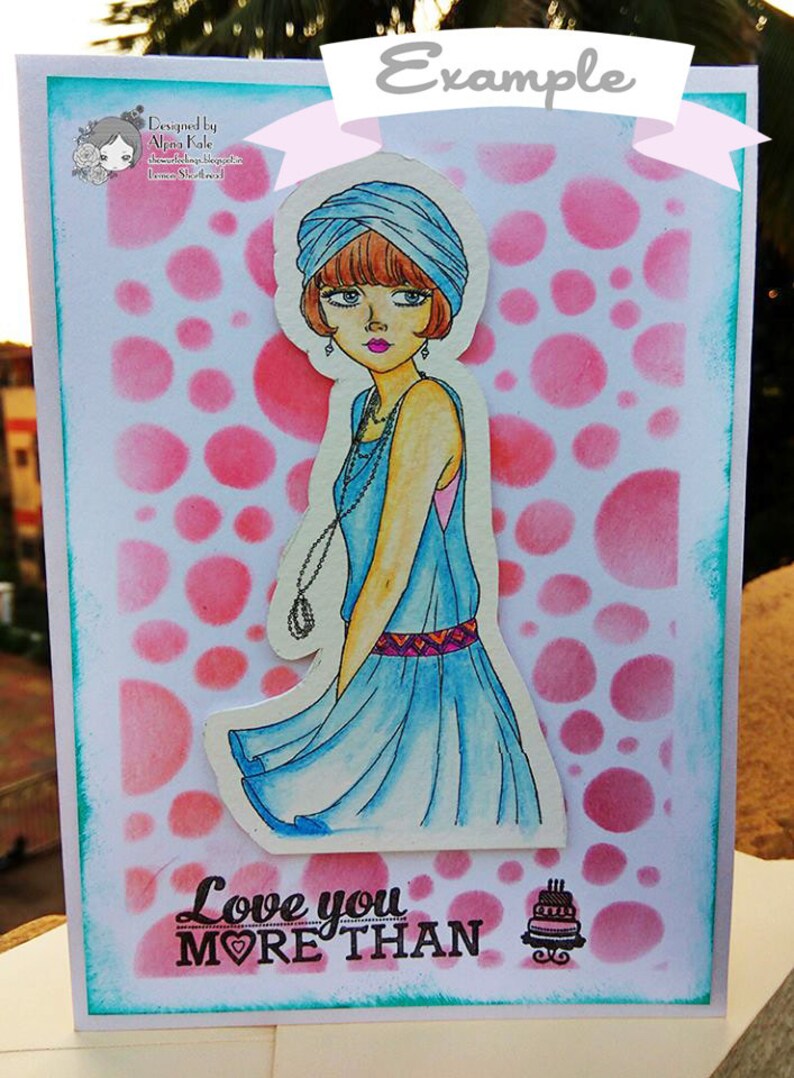 May include: A greeting card with a pink and white polka dot background. A woman with a blue turban and a blue dress is featured on the card. The text "Love you more than" is printed on the card with a heart symbol and a small cake image.