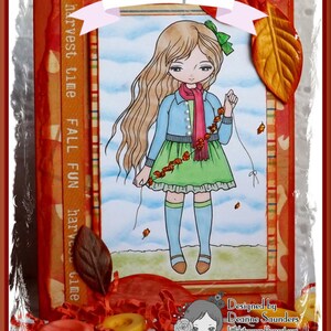 May include: A digital illustration of a girl with long blonde hair wearing a blue jean jacket, a red scarf, and a green skirt. She is holding a string of red berries and is standing in front of a background with a blue sky and white clouds. The image is framed with a red and orange border with the text "harvest time FALL FUN harvest time" written vertically on the left side. The image also includes the text "Example" at the top and "Designed by Deanne Saunders littlepaper.blogspot.com Lemon Shortbread" at the bottom.