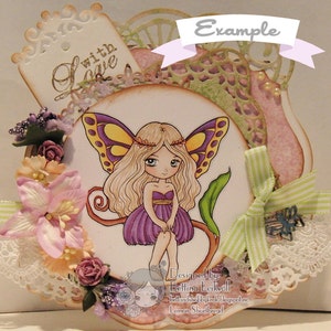 May include: A handmade card featuring a purple fairy with yellow wings and a flower crown. The card is decorated with lace, flowers, and a ribbon. The text "with love" is written on a tag in the upper left corner. The card is designed by Bettina Leikvoll.