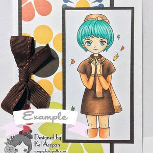 Peut inclure: Une carte marron et orange avec une fille aux cheveux bleus et une robe marron. La carte a un n&oelig;ud marron et le texte "Example" et "Designed by Kel Accopan".