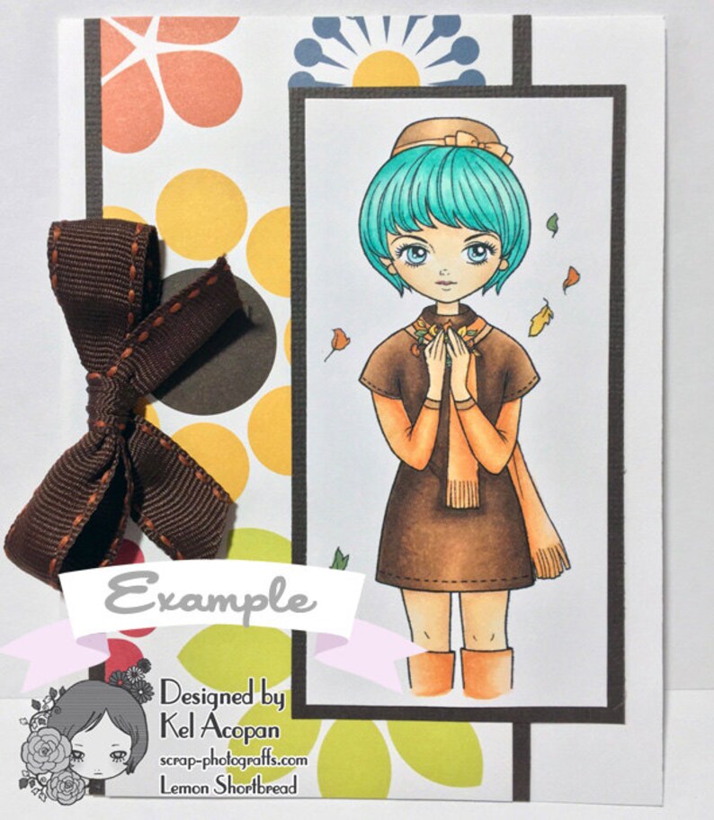 Peut inclure: Une carte marron et orange avec une fille aux cheveux bleus et une robe marron. La carte a un n&oelig;ud marron et le texte "Example" et "Designed by Kel Accopan".