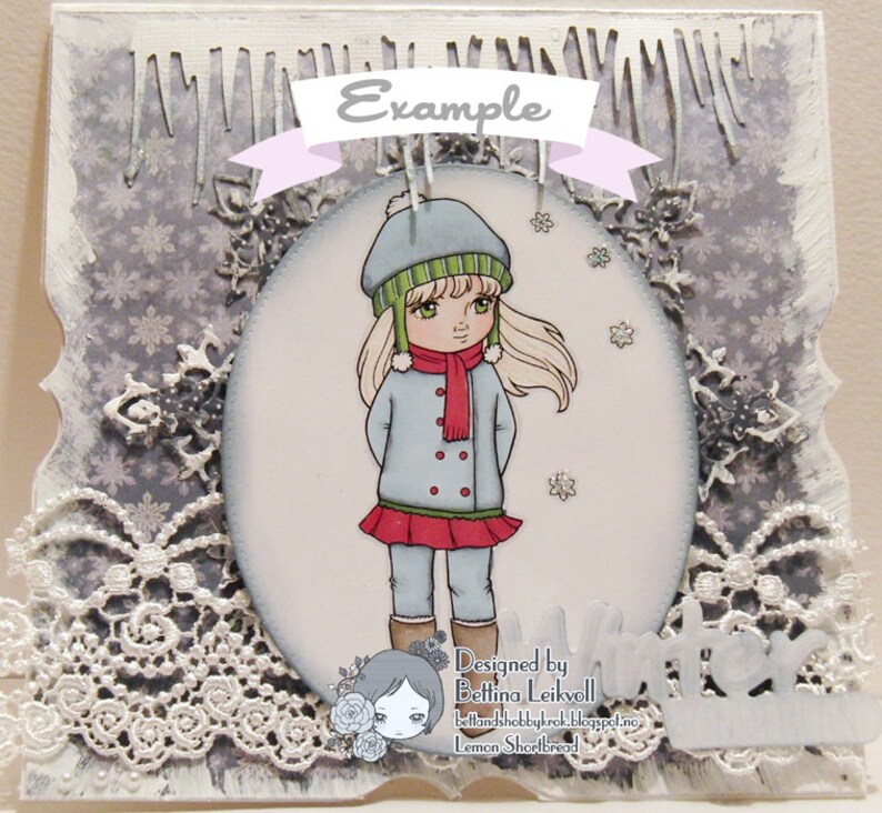 May include: A winter-themed card with a girl wearing a blue coat, red scarf, and green and white hat. The card has a white lace border and a snowflake pattern background. The text "Designed by Bettina Leikvoll" and "Lemon Shortbread" is at the bottom of the card.