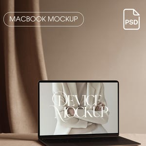 May include: A black MacBook laptop mockup with the text "DEVICE MOCKUP" on the screen. The image is set against a neutral background with a draped fabric and the text "MACBOOK MOCKUP". A "PSD" icon is in the upper right corner.