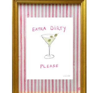 May include: A framed print with pink and white stripes on the mount. The print features a hand-drawn illustration of a martini glass with olives and the text "EXTRA DIRTY PLEASE" in pink.