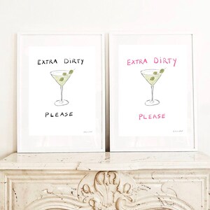 May include: Two white framed prints with the text "Extra Dirty Please" in black and pink lettering. Each print features a hand-drawn illustration of a martini glass with olives.