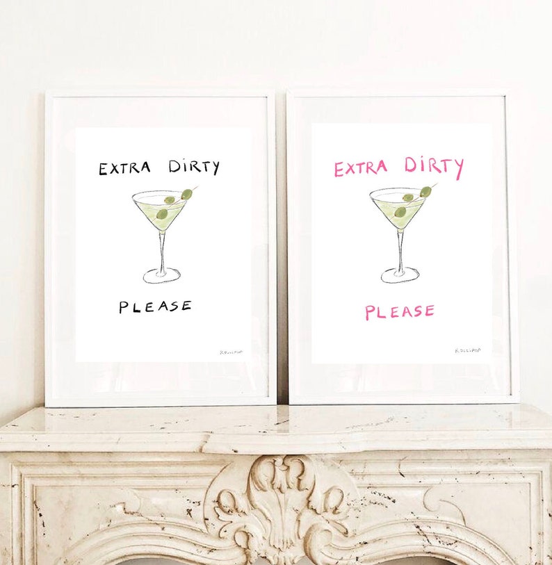 May include: Two white framed prints with the text "Extra Dirty Please" in black and pink lettering. Each print features a hand-drawn illustration of a martini glass with olives.