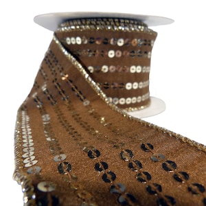May include: A roll of brown ribbon with gold sequins and trim. The ribbon is made of a textured fabric and is decorated with rows of gold sequins. The edges are trimmed with gold metallic thread.