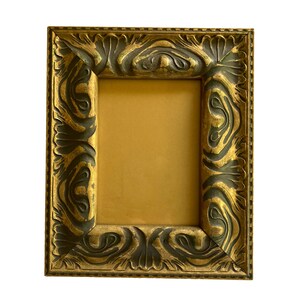 Pode incluir: Moldura retangular ornamentada com acabamento dourado e detalhes em verde escuro. A moldura apresenta um design entalhado detalhado nas bordas e um interior dourado. Ideal para exibir fotos ou obras de arte.