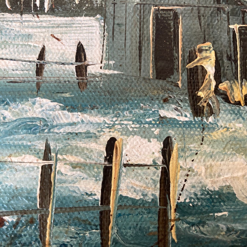 May include: An abstract painting depicting a coastal scene with a textured, impasto style. The artwork features shades of blue, white, and brown, with visible brushstrokes suggesting waves and structures. The composition evokes a sense of the sea.