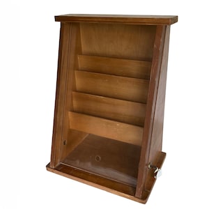 May include: A wooden display case with a glass front and shelves. The case has a triangular shape and a small latch on the side.