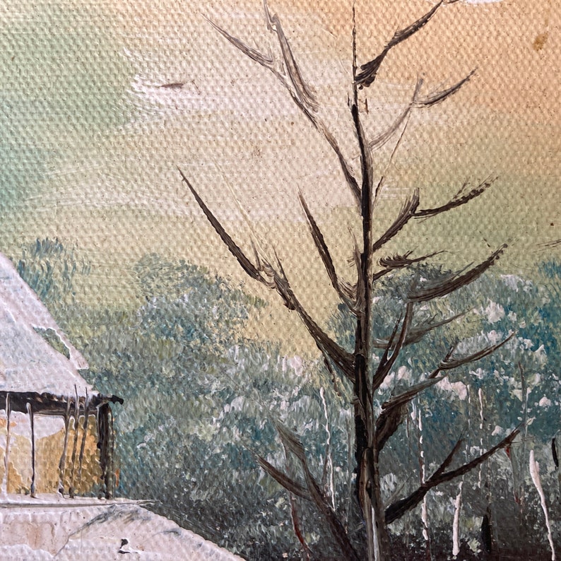 May include: Oil painting of a winter landscape featuring a snow-covered building and bare tree branches. The artwork uses muted tones of white, beige, and blue to depict a serene, cold scene. The painting has a textured canvas.