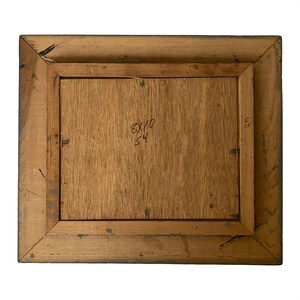 May include: Back of a framed artwork. The wooden frame is a light brown color with a darker brown border. The artwork's backing is a light brown wood. The dimensions are 8x10 inches, with the number 54 written below.